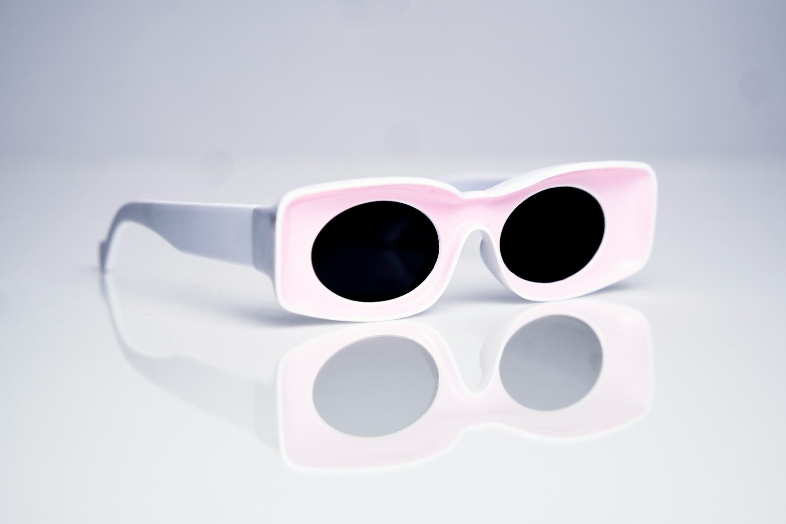 a pair of white sunglasses with black lenses
