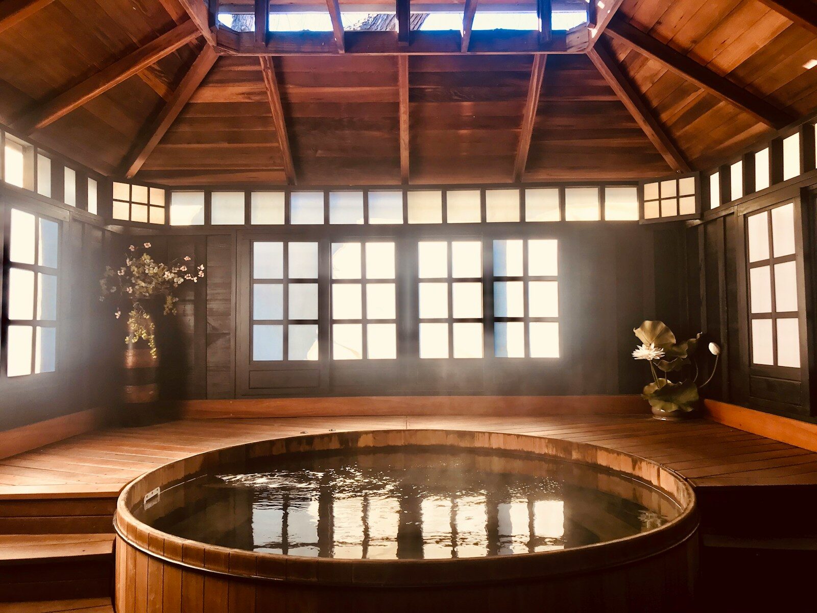 brown wooden round table near glass window